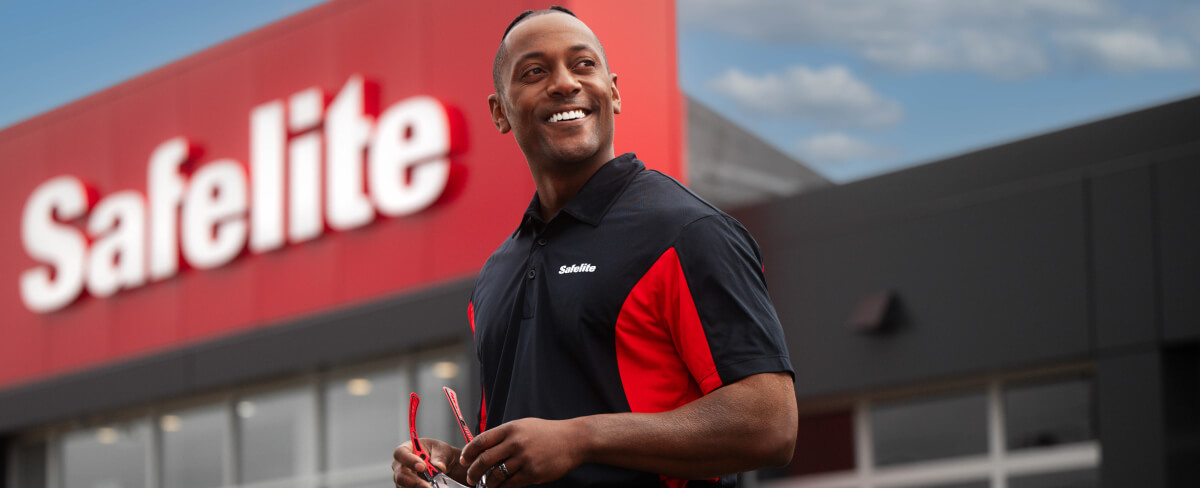 Photo of a Safelite employee standing in front of a Safelite shop.