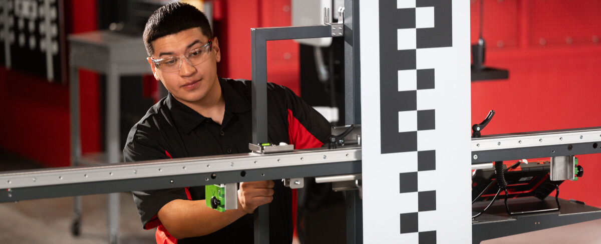 A Safelite technician wearing gloves recalibrating a vehicle’s ADAS system